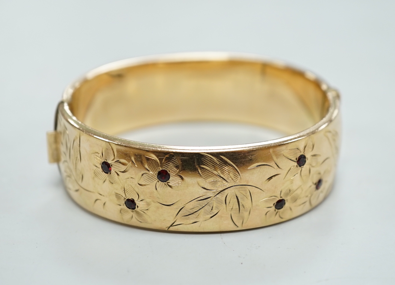A 1960's 9ct gold hinged bangle, by Smith & Pepper, 30.4 grams and a rolled gold bangle.